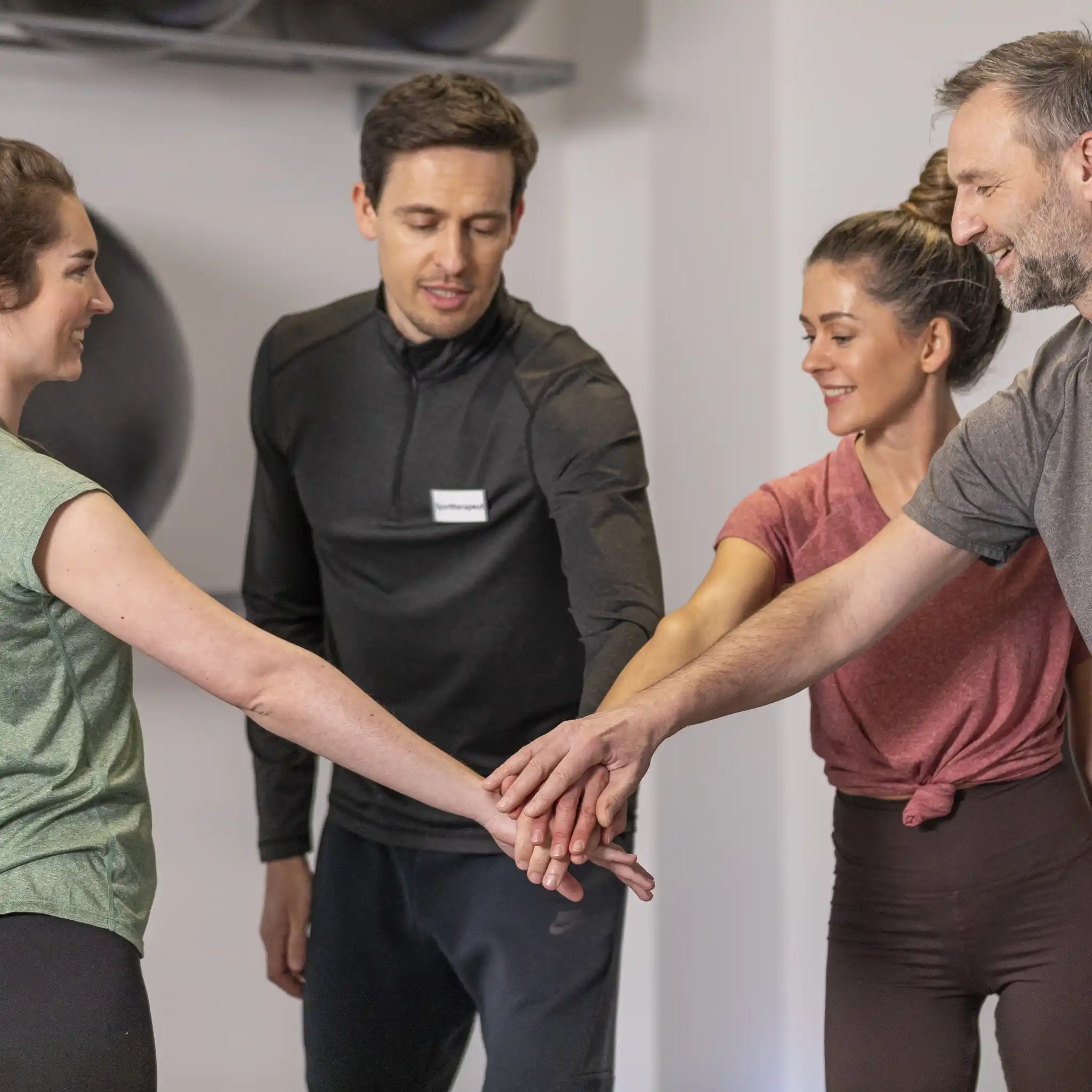 Physiotherapie Team legen Hände zusammen